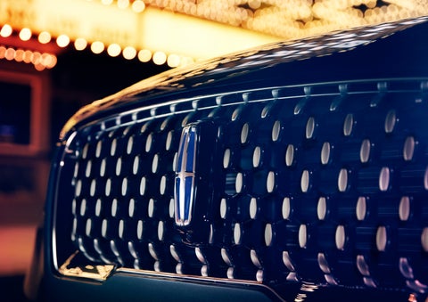 The Corsair Grand Touring grille shows floating chrome ovals that catch the glowing light of a theater marquee and frame the distinctive Lincoln Star | Evergreen Lincoln in Issaquah WA