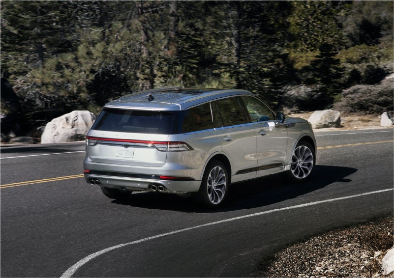 A 2023 Lincoln Aviator® Grand Touring model is shown being driven on a tight turn of a mountain road | Evergreen Lincoln in Issaquah WA