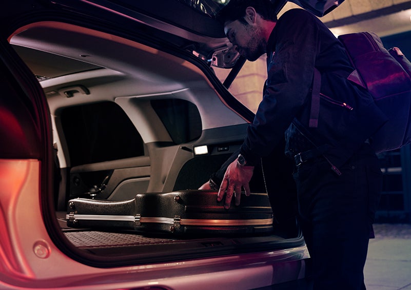 A man is shown loading cargo into the rear of a 2023 Lincoln Corsair® SUV with the second-row seats folded flat. | Evergreen Lincoln in Issaquah WA