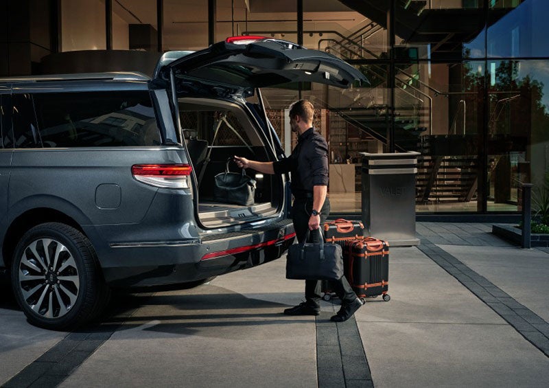 A valet is unloading luggage from the rear cargo area of a 2023 Lincoln Navigator SUV. | Evergreen Lincoln in Issaquah WA