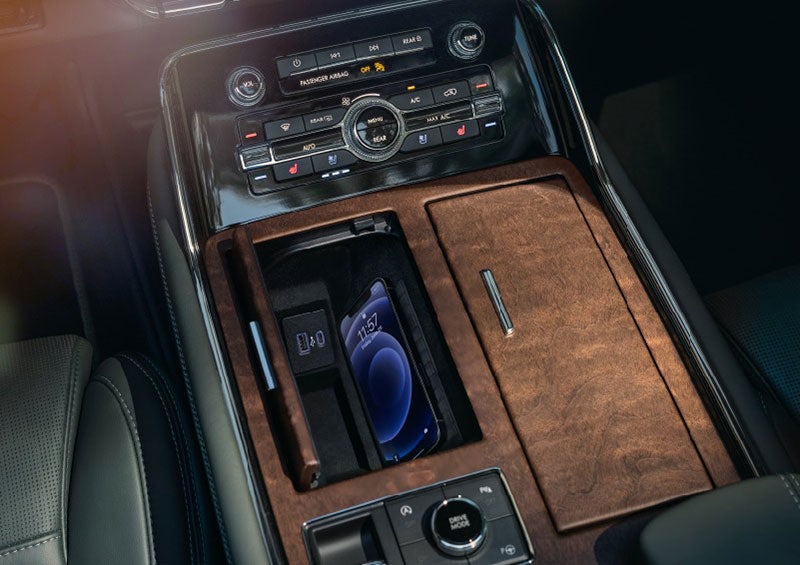 A smartphone is charging on the wireless charging pad* in the front center console cubby. | Evergreen Lincoln in Issaquah WA
