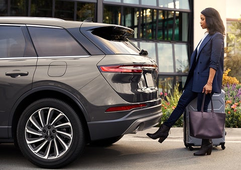 A woman with her hands full uses her foot to activate the available hands-free liftgate. | Evergreen Lincoln in Issaquah WA