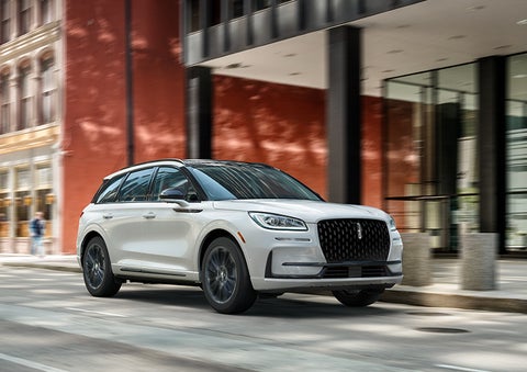 The 2024 Lincoln Corsair® SUV with the Jet Appearance Package and a Pristine White exterior is parked on a city street. | Evergreen Lincoln in Issaquah WA
