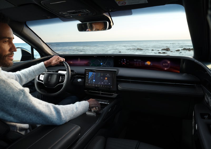 A driver of a parked 2024 Lincoln Nautilus® SUV takes a relaxing moment at a seaside overlook while inside his Nautilus. | Evergreen Lincoln in Issaquah WA